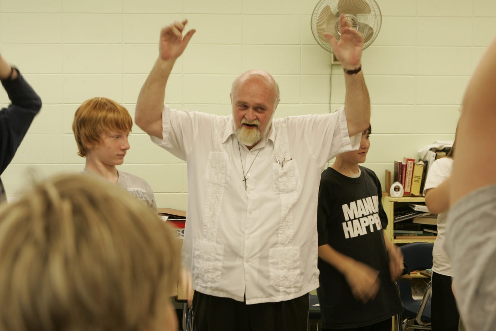 Ken leading a roomful of students, arms raised
