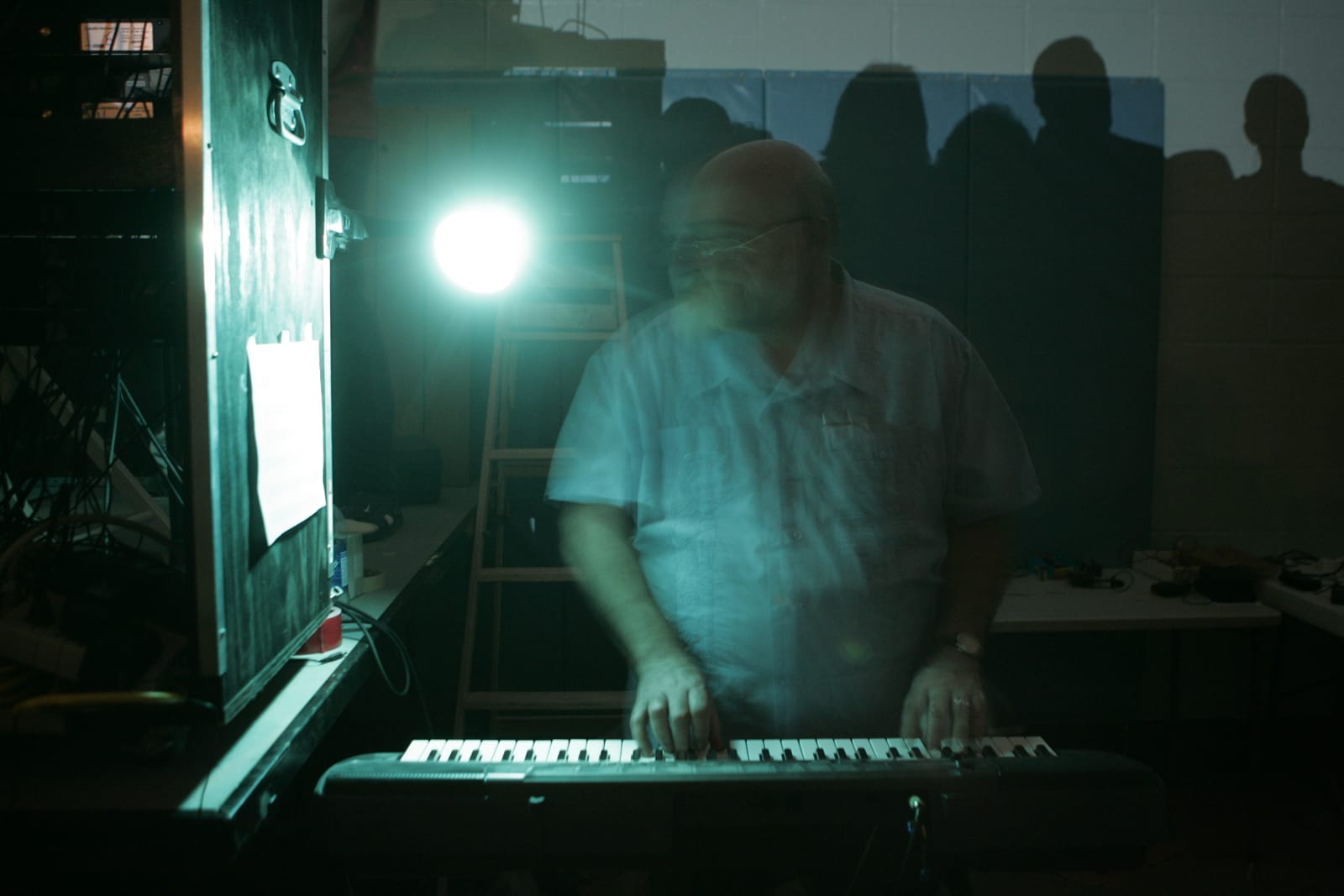 Ken at the keyboard under a stage light