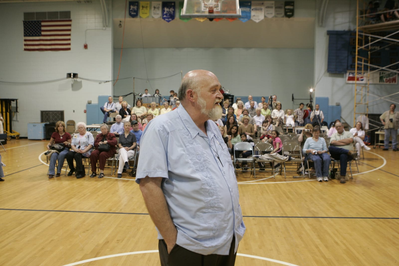 Ken addressing a full gymnasium audience
