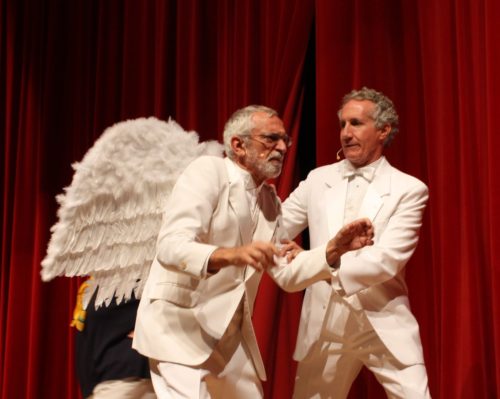 Cast in white costumes on stage