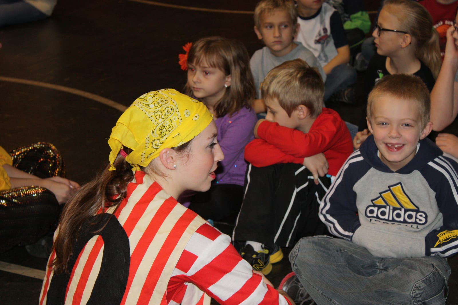 Costumed pirate in bandana among the seated children