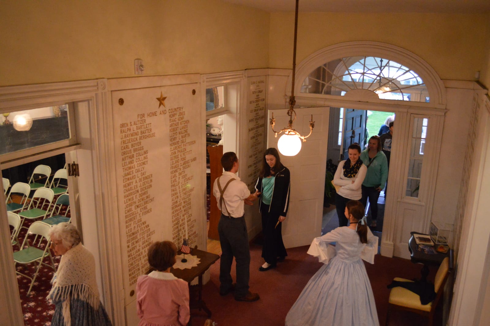 Costumed cast in the historic hall, with the audience seated on the site itself