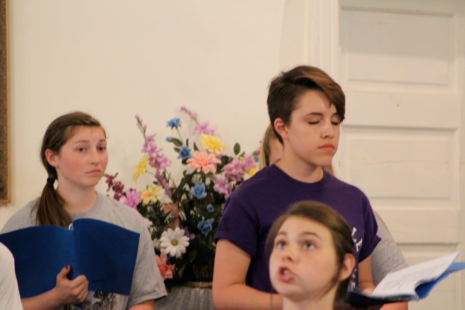 Cast members performing from their blue readers'-theatre script folders