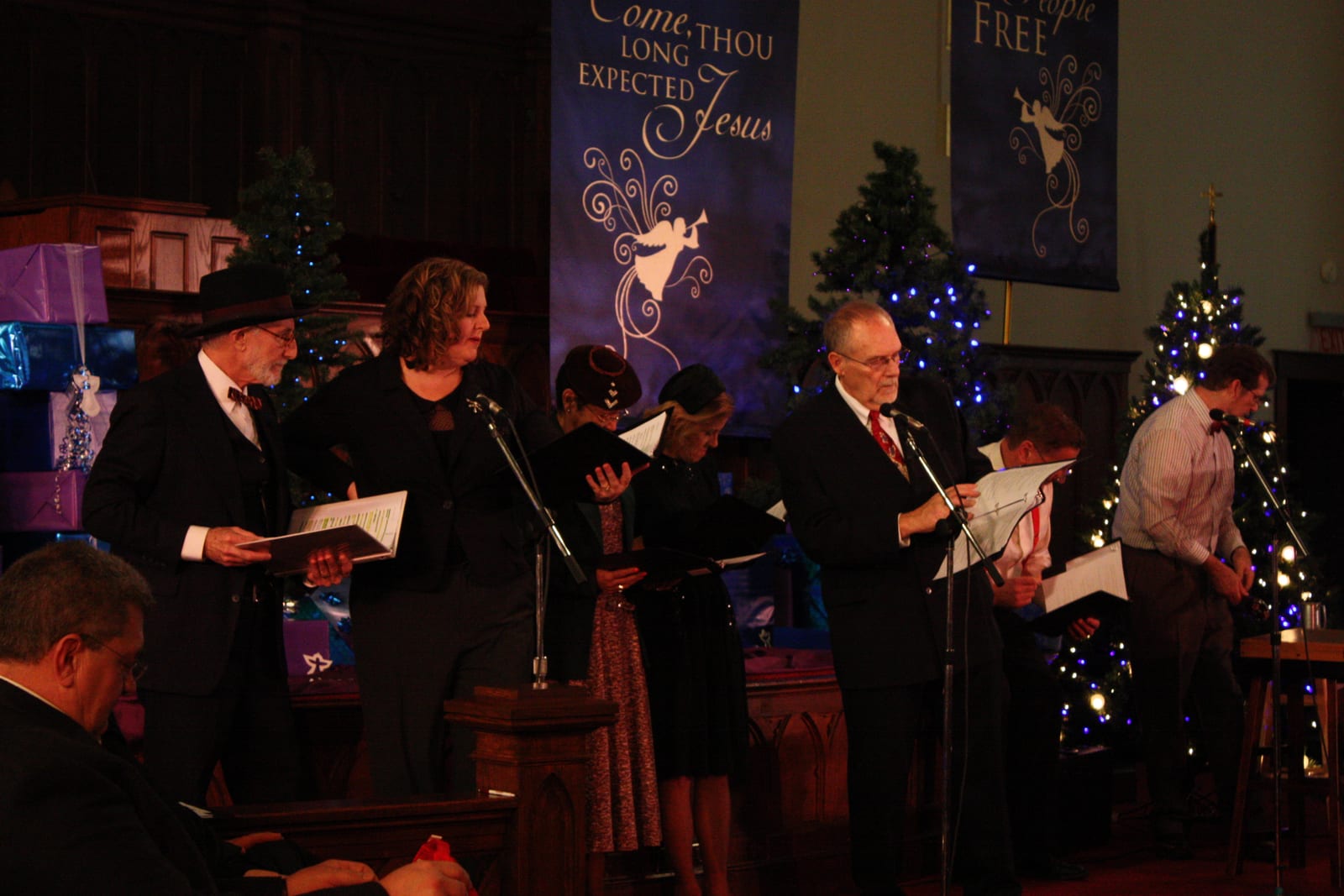 The radio-style cast reading at the standing microphones