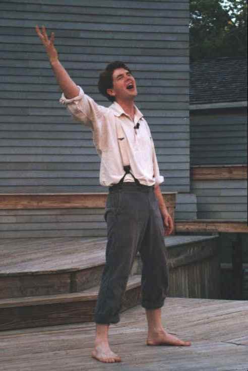 Young Lincoln singing on stage with arm raised