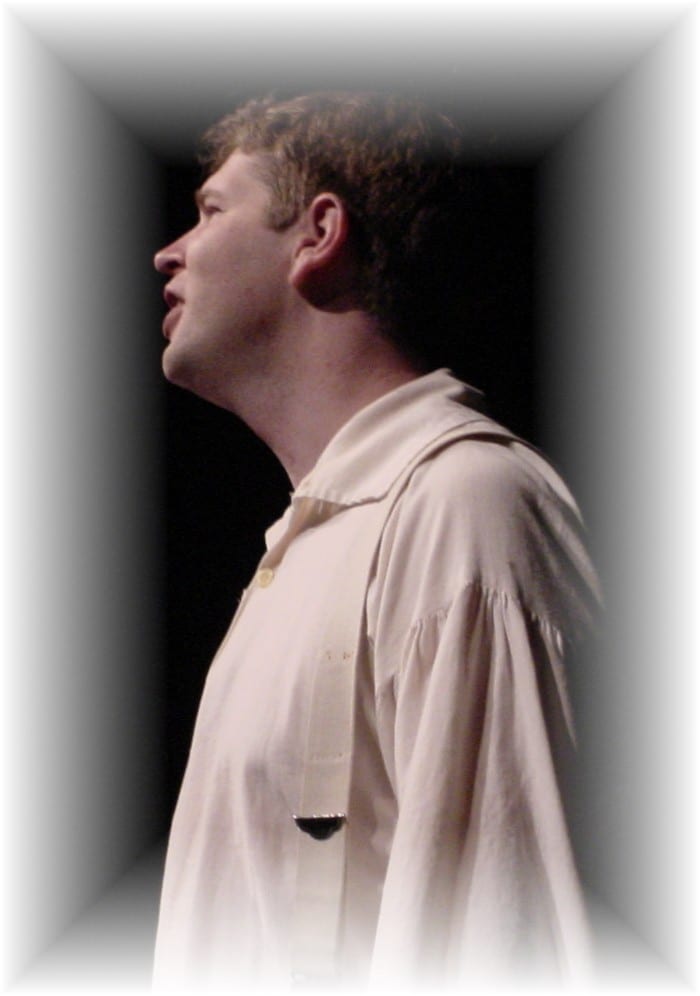 Performer in profile singing on stage