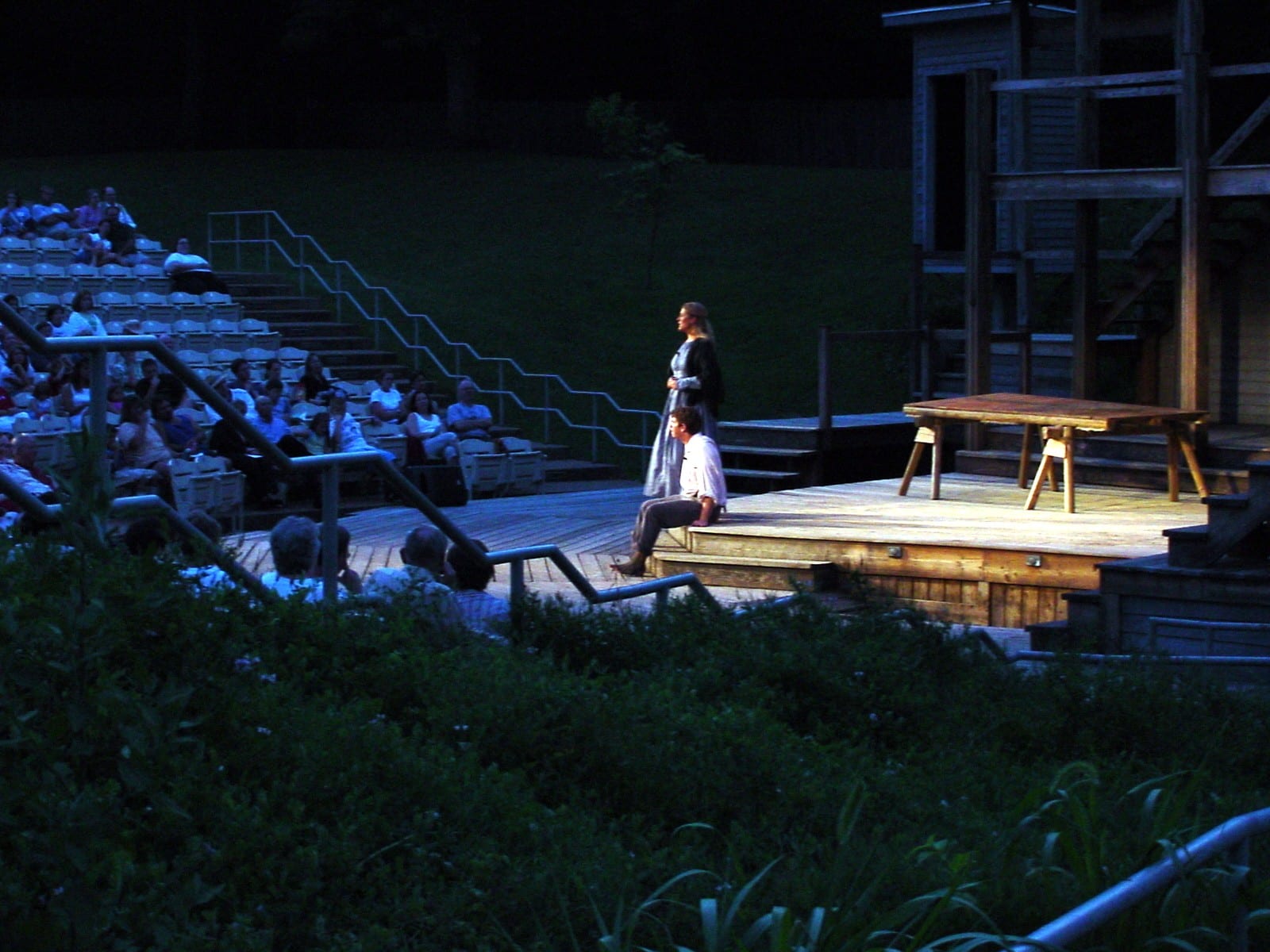 Actors on the outdoor stage at dusk before the audience
